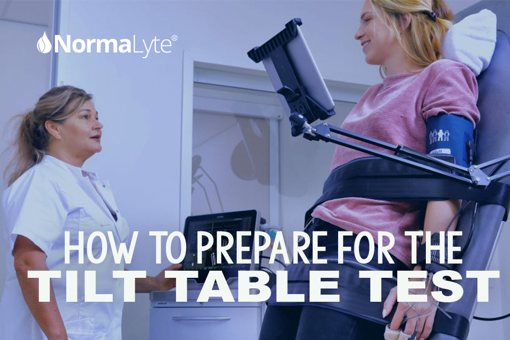 Woman on a tilt table with a blood pressure, heart rate, and oxygen cuff on smiling at the doctor who is performing the test. NormaLyte ORS Electrolyte for POTS