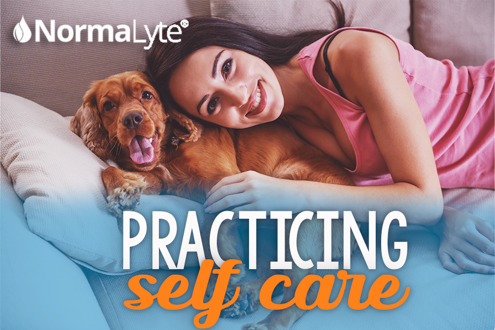 Woman snuggling with dog on couch with caption that reads Practicing Self Care. NormaLyte logo