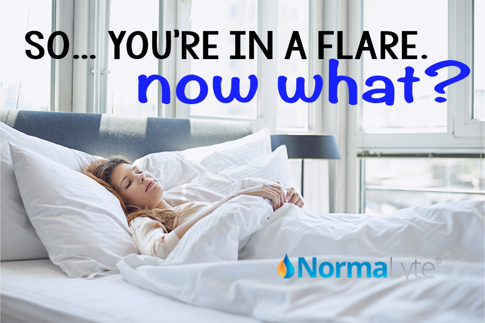Woman laying in a nice bed with a chronic illness flare.  The caption reads "So... you're in a flare. Now what?"