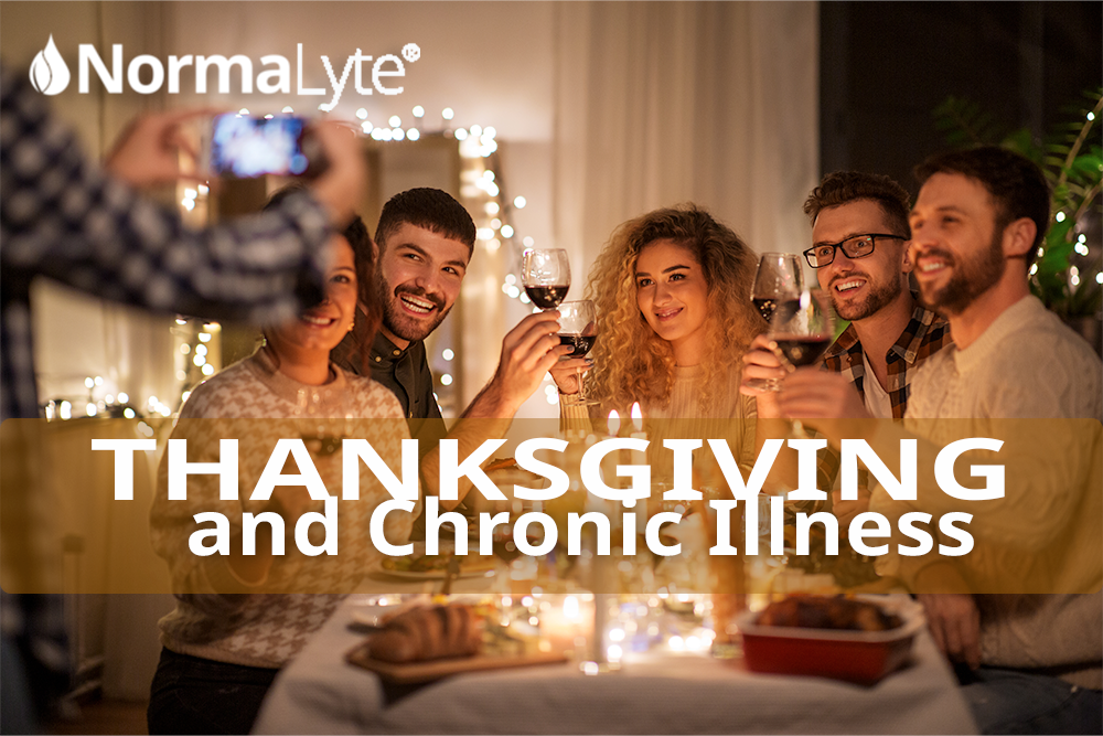 Image is a family sitting together at a table with someone snapping a photo.  Caption reads: Thanksgiving and Chronic Illness | NormaLyte ORS Electrolyte for POTS