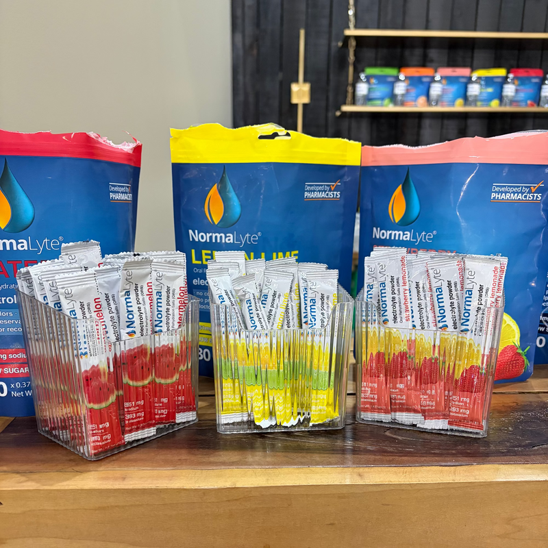 NormaLyte packets on a wooden surface with shelves in the background