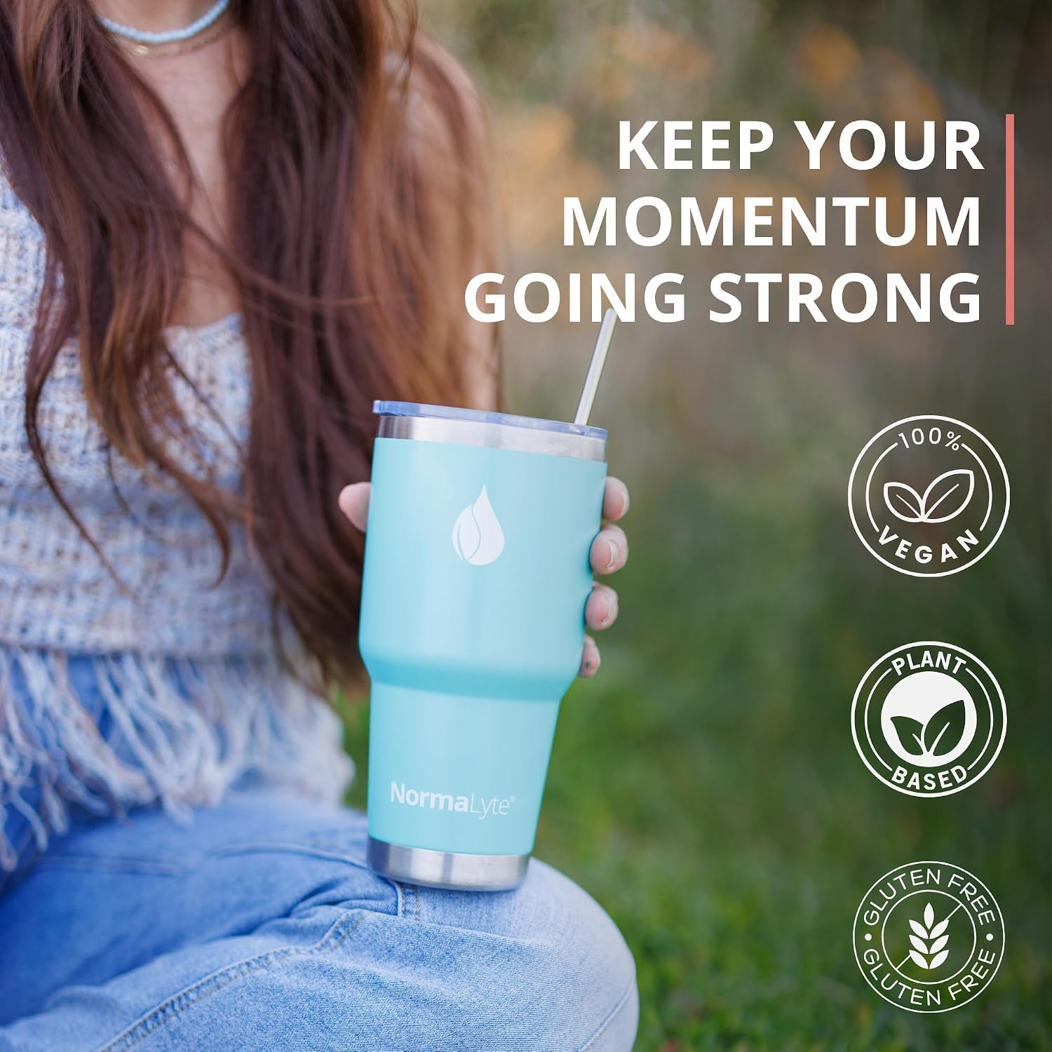 A person outdoors holds a light blue NormaLyte vacuum-insulated tumbler with a straw. The image includes marketing text reading 'KEEP YOUR MOMENTUM GOING STRONG' and badges stating '100% VEGAN', 'PLANT BASED', and 'GLUTEN FREE'.