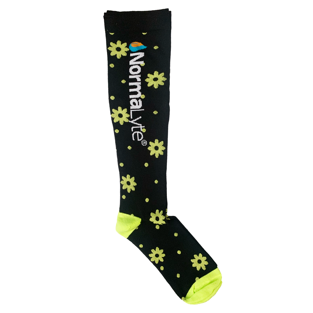 A single black NormaLyte graduated compression sock featuring a neon yellow daisy and dot pattern with a matching bright yellow heel and toe