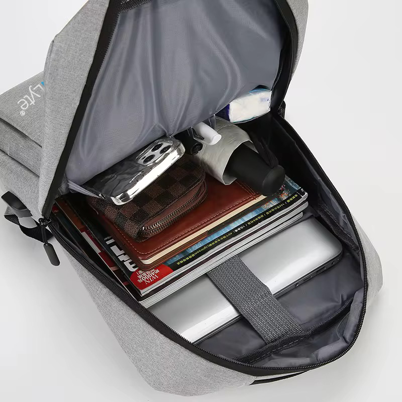 Interior view of the gray NormaLyte durable everyday backpack showing its storage capacity, organized compartments, and laptop sleeve