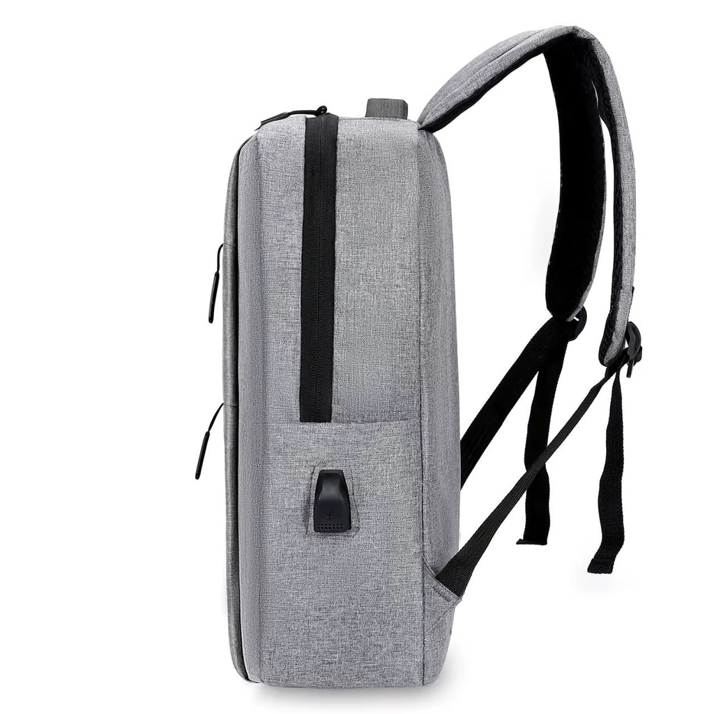 Side profile of the gray NormaLyte durable everyday backpack for work and travel, showing its slim design and external USB charging port