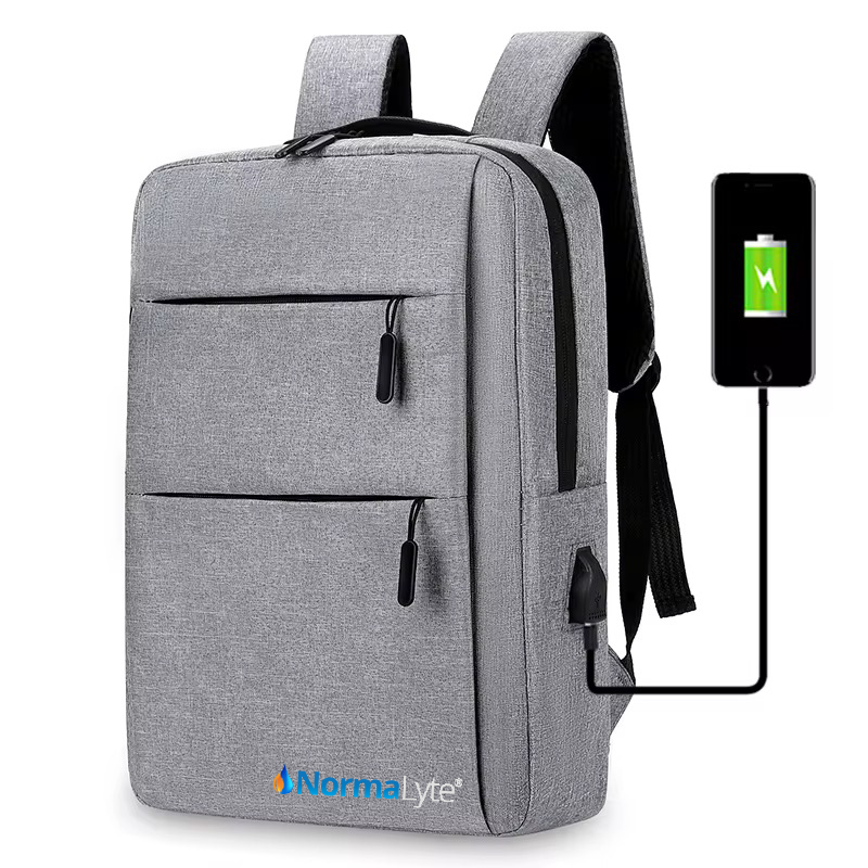 Gray NormaLyte durable everyday travel backpack showing a smartphone plugged into the built-in external USB charging port